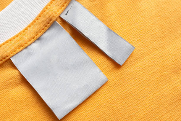 istock Blank white laundry care clothes label on yellow fabric texture background 1419732230