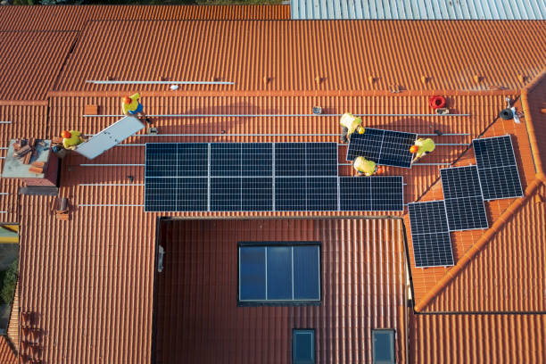 istock Aerial view of professional technicians installing photovoltaic system on roof. 1419732482