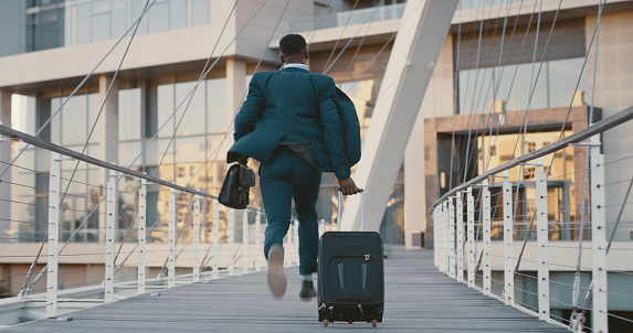 Businessman, on an airport terminal with luggage walking to get on a plane for a business deal. Young male, with ticket on his way to flight boarding gate, for travel, vacation journey on an airplane