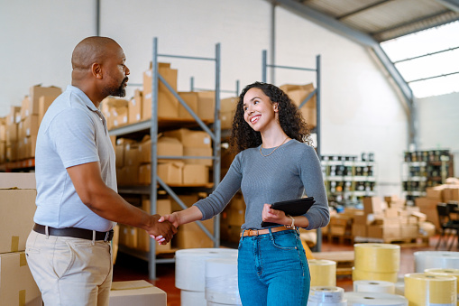 Shipping, logistics and cargo worker do handshake in b2b and team partnership deal or thank you in a meeting in a warehouse. Supply chain, delivery and stock management meeting with business success