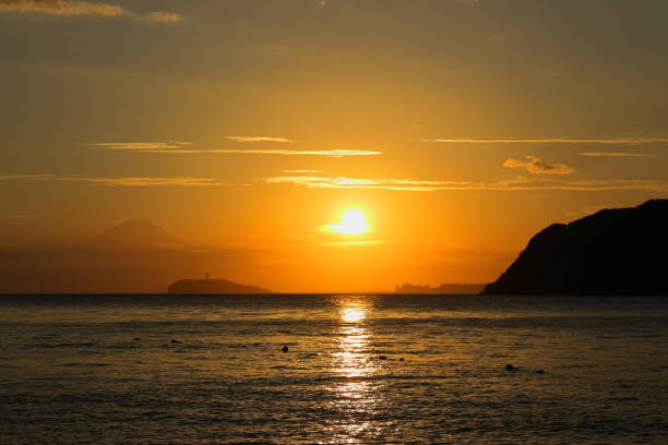 Zushi coast in mid summer, Silhouette of Enoshima and Mt. Fuji floating in the sunset.