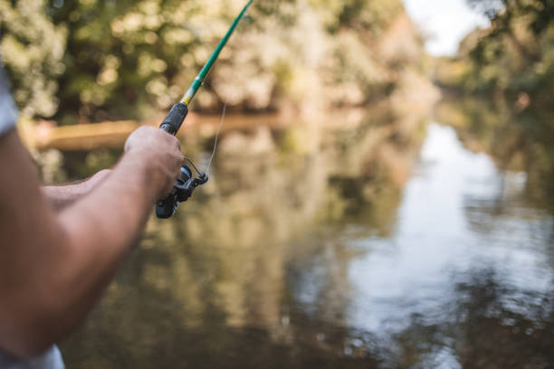 An unrecognizable man spends the day enjoying his favorite hobby, fishing