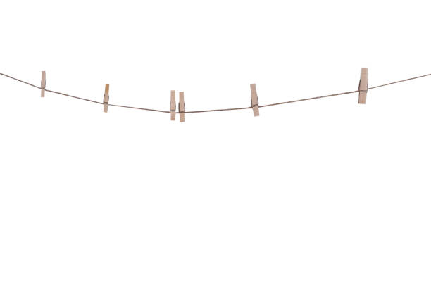 istock Six wood clothes pegs patterns hanging on brown string isolated on white background , clipping path 1419755955