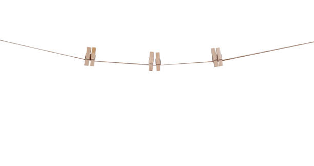 istock Three pair of wood clothes clip patterns hanging on brown string isolated on white background , clipping path 1419760800