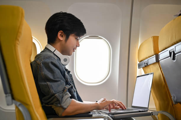istock Hipster Asian male traveler passenger using laptop during the flight. remote working concept 1419766054