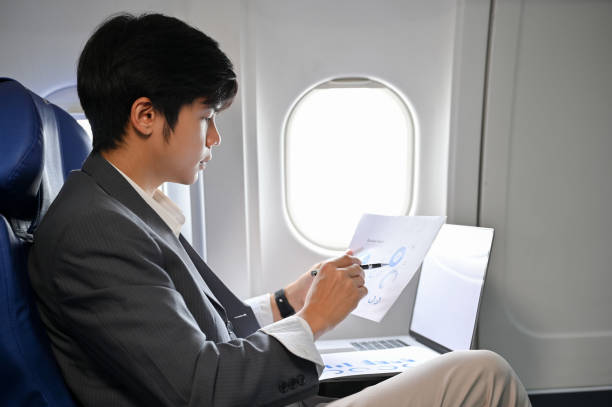 istock Professional Asian businessman concentrating analyzing a financial data during the flight 1419766112