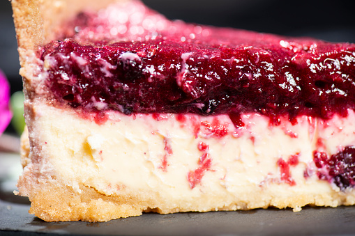 Homemade mixed berry cheesecake with a biscuit crumb and fruit puree.
