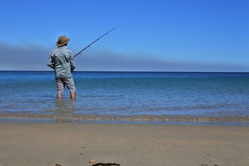 Australian man (male age 40-50) fishing on a remote beach in the Kimberley region Western Australia