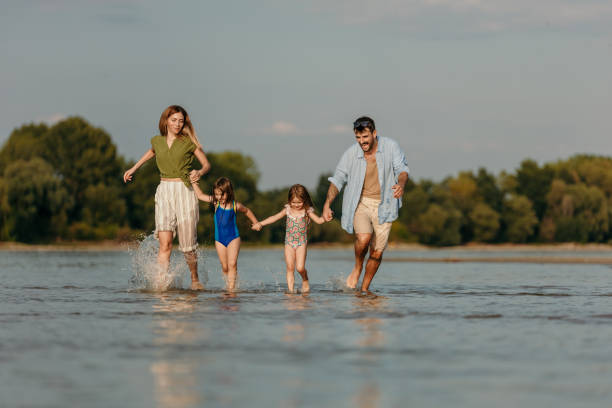 istock Playful casual family enjoying playing at beach 1419785892