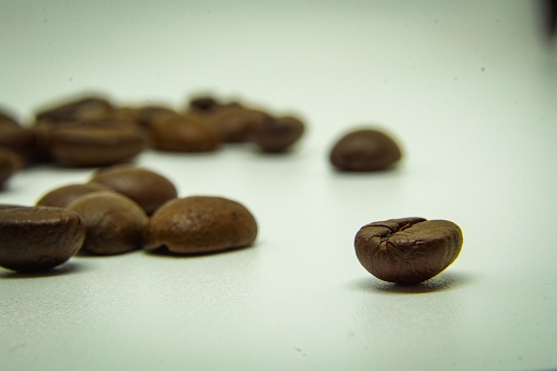 The way coffee beans lay on a white background, elegant and delicious coffee beans and the aroma of morning coffee.