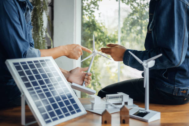 istock Close-up at windmill, Engineers pointing at wind turbines with their hands. To jointly design the use of renewable energy with wind and solar energy. Concept of using renewable energy. 1419789914