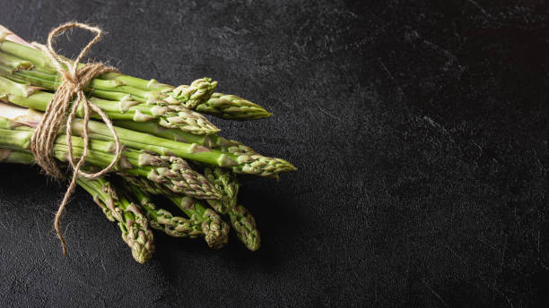 istock Green asparagus on a black background with copy space 1419796230