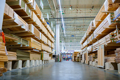 racks with wooden boards and slabs in the warehouse of the hardware store.