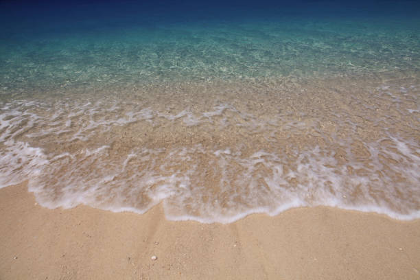 View of wave crashing on sandy Egremni Beach, Lefkada Island, Greece.