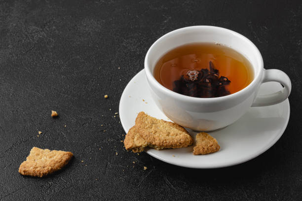 istock Cup of black tea with cookies on dark background. 1419799215