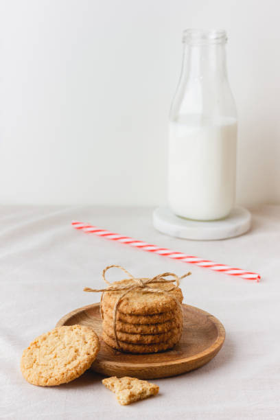 oatmeal cookies on a wooden plate - milk milk bottle drinking straw cookie imagens e fotografias de stock