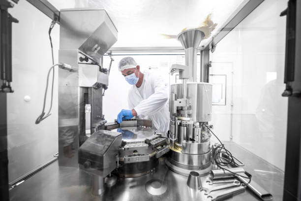 istock Pharmaceutical technician in a protective clothing equipment seen in a laboratory during a manufacturing process 1419814991