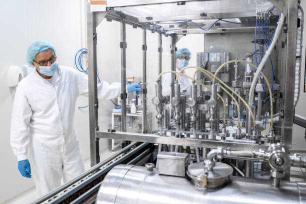 istock Two fully equipped coworkers in protective workwear seen in a pharmaceutical laboratory 1419815086