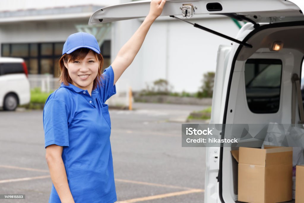 A woman opens the door of a light van and finds cardboard boxes piled up. Driver of a light van or light cargo. Home Delivery Stock Photo