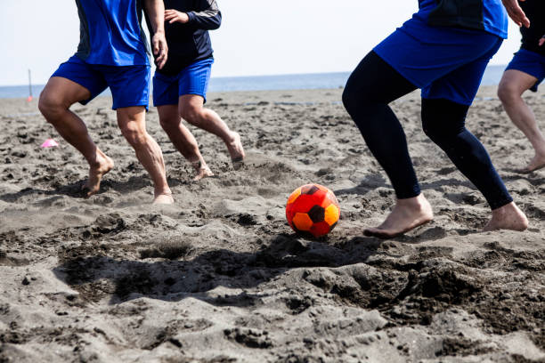 istock Man's feet playing soccer on the sand 1419823121