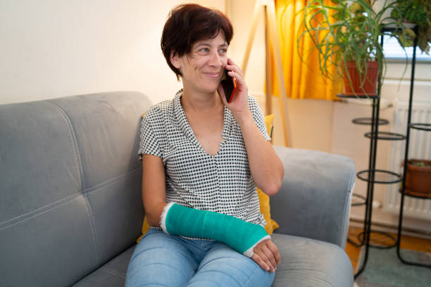 mujer con el brazo roto hablando por teléfono - dropped call fotografías e imágenes de stock
