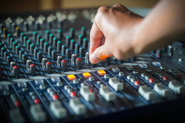 Men's hands are controlling the console of a large hi-fi system
