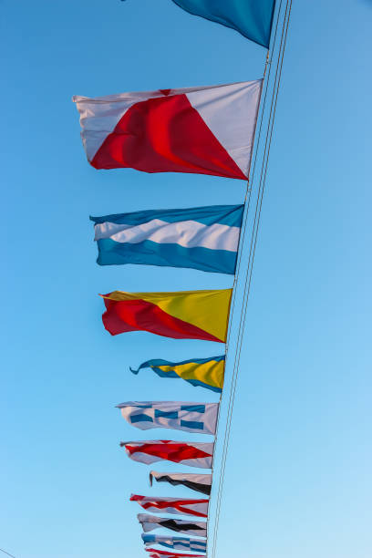 istock International maritime signal flags are waving on wind under blue cloudy sky. 1419835820