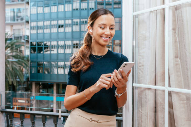 istock Young businesswoman using smartphone standing on balcony 1419835831