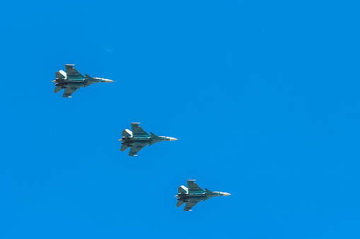 Fighter jets flying in formation over the clouds.