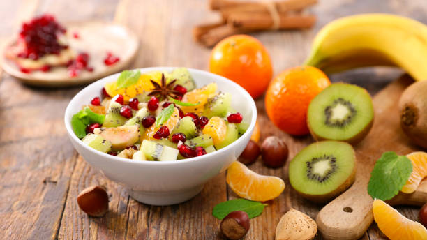 fresh mixed fruit salad ( clementine, banana, kiwi and pomegranate) stock photo