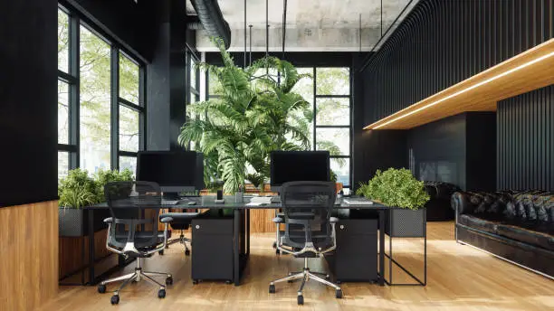 Interior of a modern open plan office space with dark gray furniture and city view.