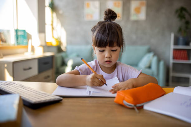 istock Japanese girl doing homework while sitting at desk at home 1419842520