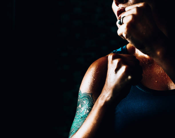 High contrast image with strong woman in boxe defense posture. Training alone and sport athlete people. Concept of self defence and empowerment lady. Female people close up sporty