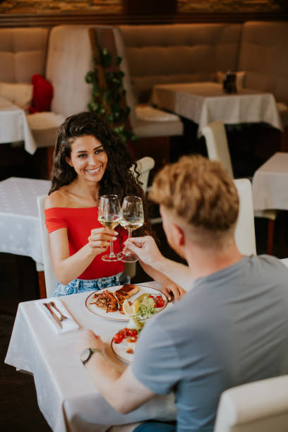 Young couple having lunch with white wine in the restaurant stock photo