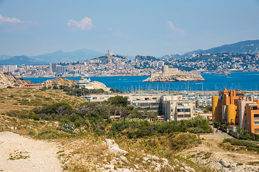 Buildings of the port and village of Ratonneau island on the Frioul archipelago with a view on Marseille on a sunny day