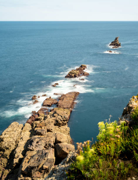 istock Rocky cliffs, some covered in vegetation, dropping into the ocean 1419857928