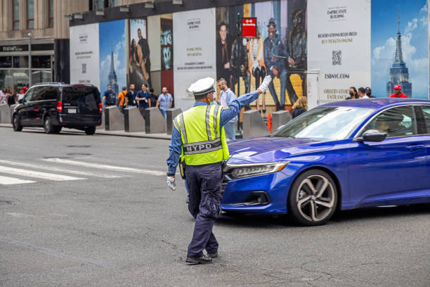 Manhattan, New York, NY, USA - July 12th 2022: Police officer handling the traffic in the intersection between 5th Avenue and West 34th Street
