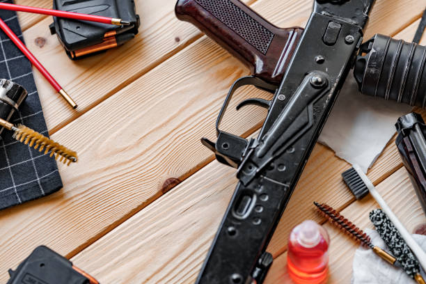 istock Black disassembled shotgun and cleaning tools on wooden table . 1419858780