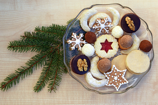 Several kinds of Christmas cookies on a glass plate, spruce twig decoration
