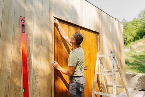 Photo of a man working on a garden house