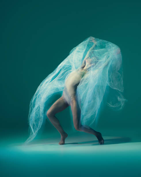 istock Graceful ballet dancer dancing with white cloth, fabric isolated on green background. Art, motion, action, flexibility, inspiration concept. 1419868470