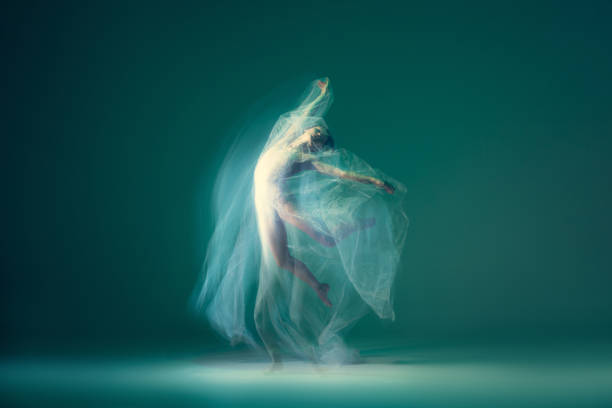 istock Graceful ballet dancer dancing with white cloth, fabric isolated on green background. Art, motion, action, flexibility, inspiration concept. 1419868502