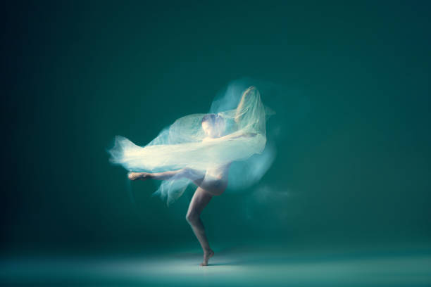 istock Graceful ballet dancer dancing with white cloth, fabric isolated on green background. Art, motion, action, flexibility, inspiration concept. 1419868546