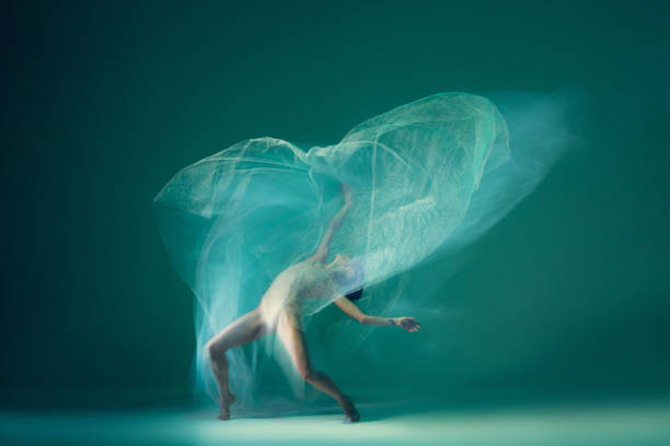 istock Graceful ballet dancer dancing with white cloth, fabric isolated on green background. Art, motion, action, flexibility, inspiration concept. 1419868581