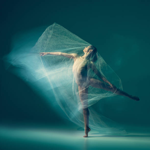 istock Graceful ballet dancer dancing with white cloth, fabric isolated on green background. Art, motion, action, flexibility, inspiration concept. 1419868586