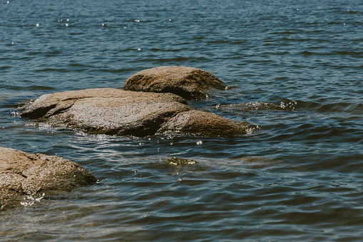 A close-up of large stones in the water.