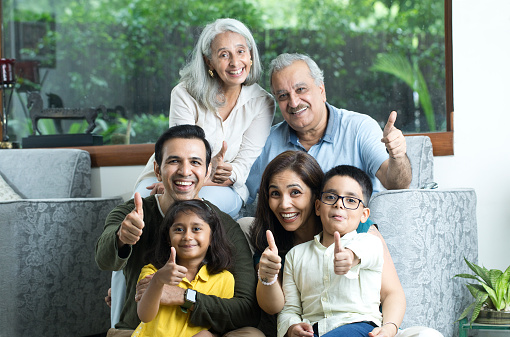 Multi-Generation Family Giving Thumbs Up Gesture And Smiling