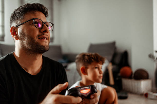 Father and son playing video games at home