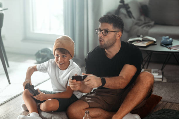 istock Father and son playing video games at home 1419870634