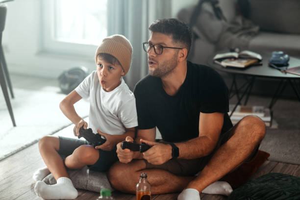 istock Father and son playing video games at home 1419870958